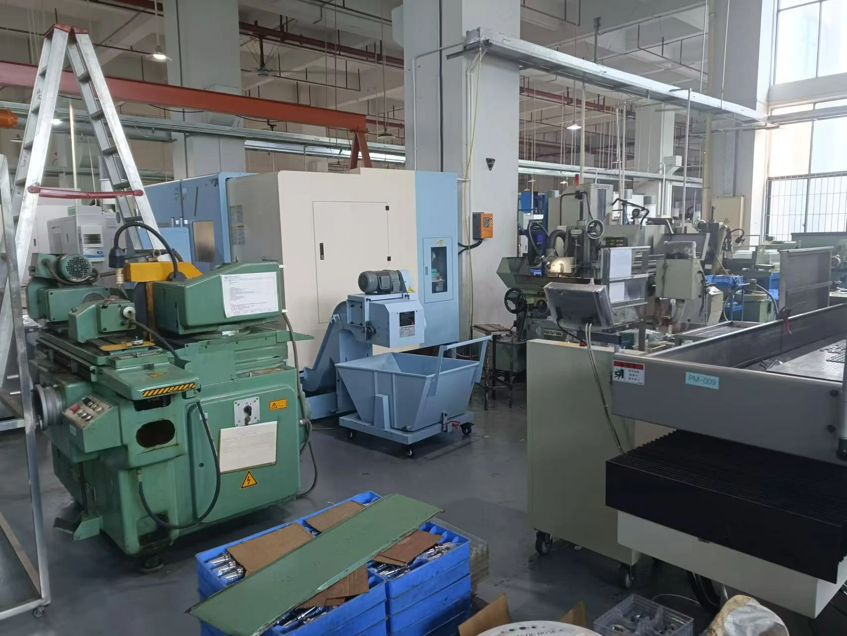 Wide factory workshop view equipped with surface grinders, milling machines and multi-axis CNC processing equipment