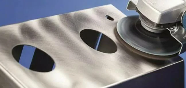 A power grinder polishing a custom metal part to achieve a smooth surface finish.