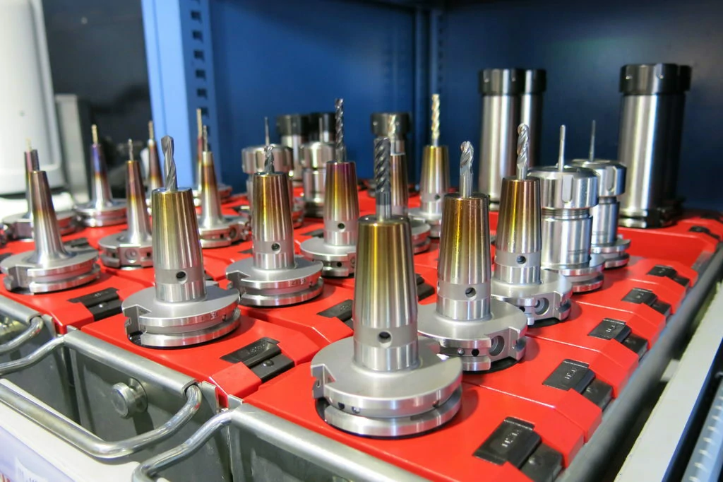 A diverse array of high-precision CNC milling cutters, carbide end mills, and tool holders neatly organized on a rack at WEHAO CNC machining facility.