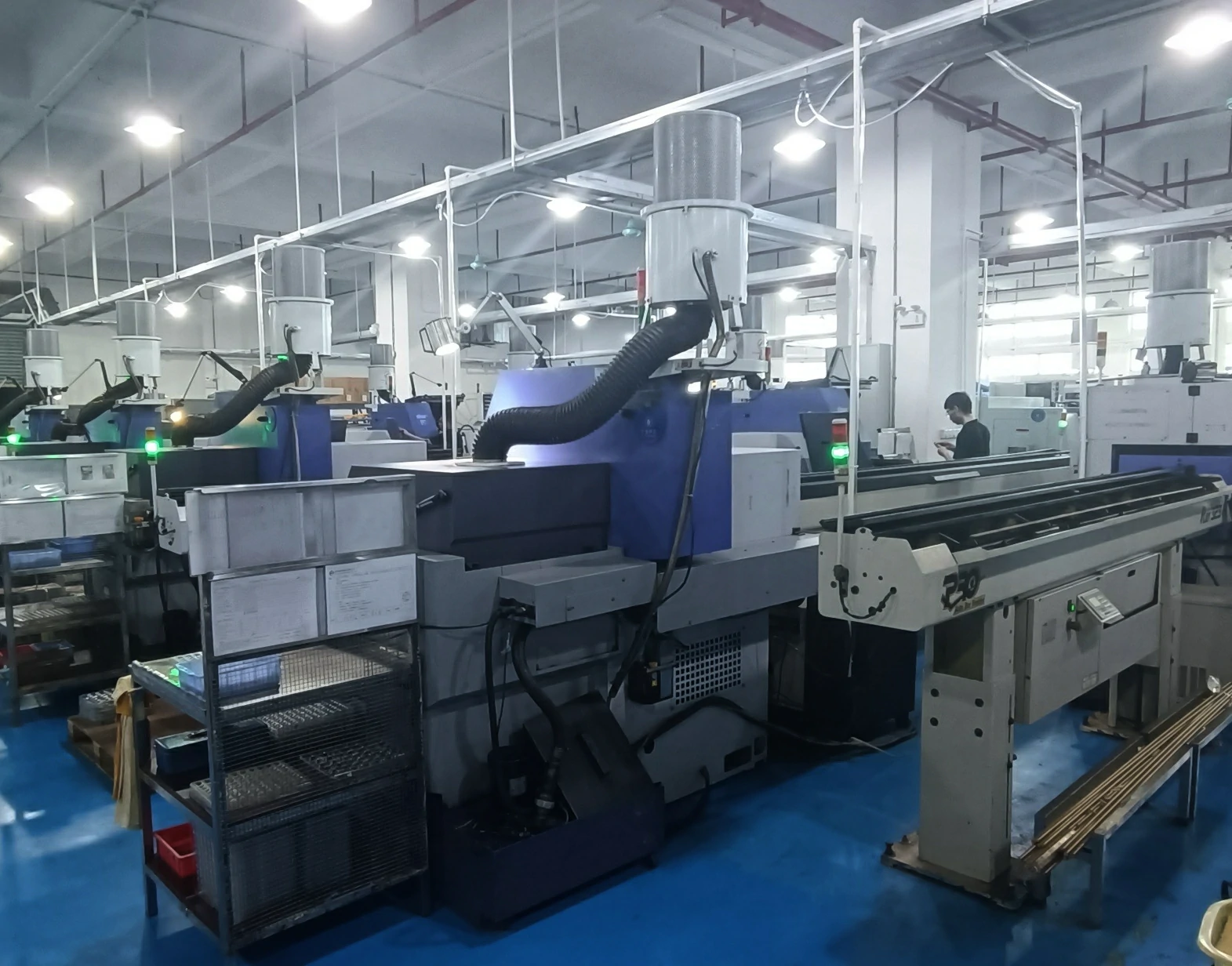 Wide factory floor view with rows of automated CNC lathes equipped with oil mist purification systems for batch metal processing