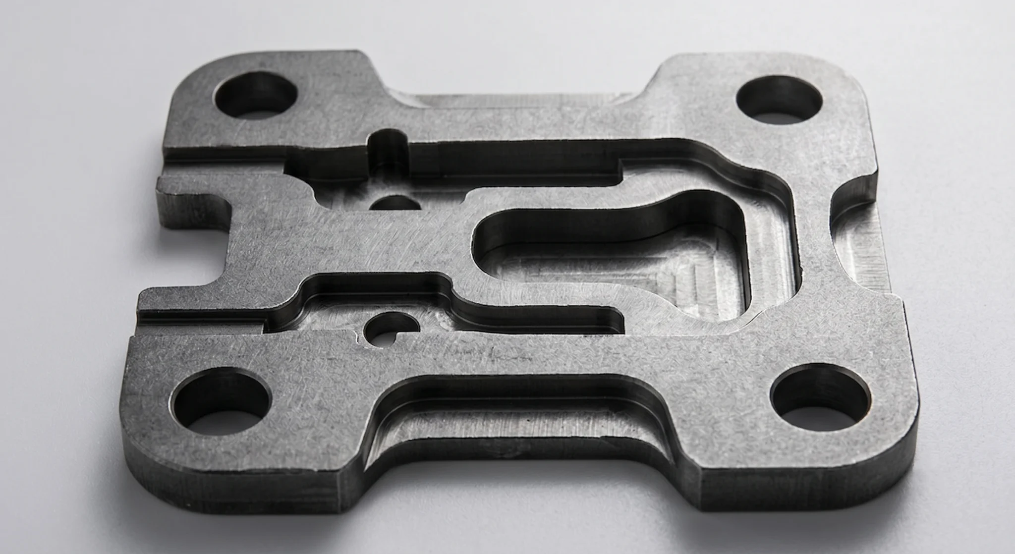 High-power CNC mild steel component with complex profiling and large mounting holes showcasing clean cuts